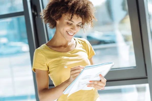 Cintura arriba de alegre estudiante afro-americana planeando su día — Foto de Stock