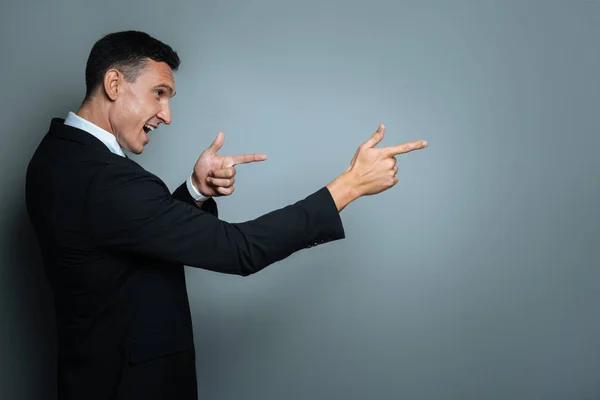 Feliz hombre alegre señalando delante de él — Foto de Stock