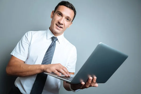 Piacevole bell'uomo con un computer portatile in mano — Foto Stock