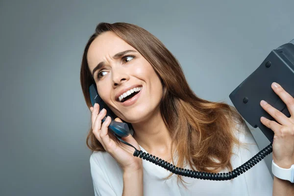 Pěkný emotivní žena držící telefon přijímač — Stock fotografie