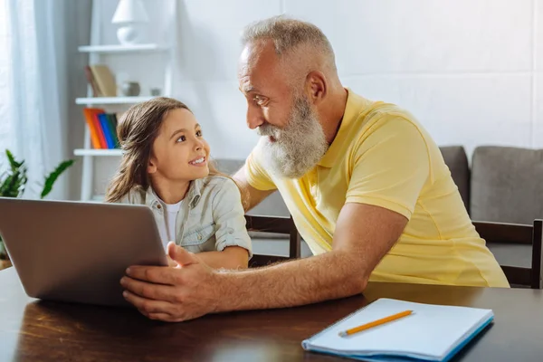 Grandfather and granddaughter discussing what video to watch — Stock Photo, Image