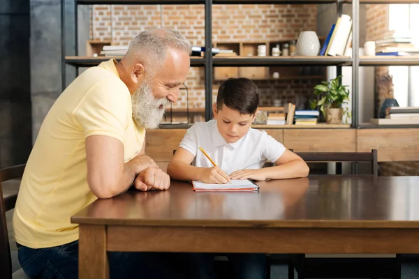 Loving grandfather watching his grandson do sums — Stock Photo, Image