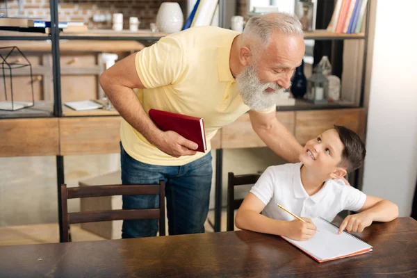 Little schoolboy asking grandfathers advice on homework — Stock Photo, Image