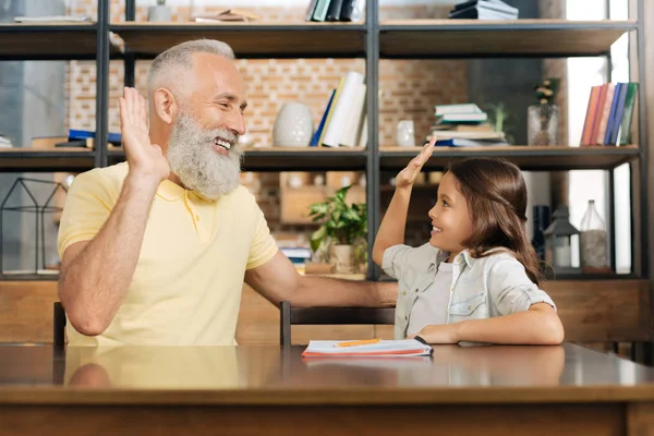 Schattig klein meisje en grootvader high-fiving elkaar — Stockfoto