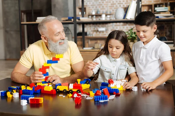 Avô e seus netos montando um novo conjunto de construção — Fotografia de Stock