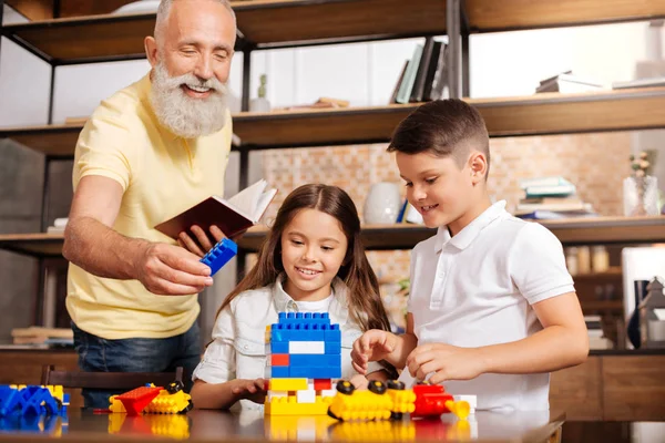 Grand-père remettre la pièce de construction à ses petits-enfants — Photo