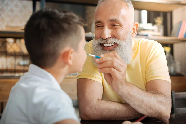 Счастливый дедушка рисует нос своего внука — стоковое фото