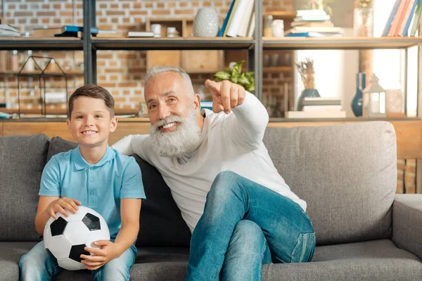 Abuelo y nieto disfrutando del juego de fútbol en la TV —  Fotos de Stock