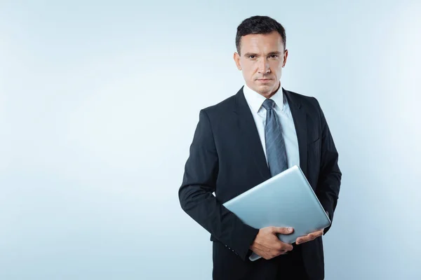 Sério homem confiante segurando um laptop — Fotografia de Stock