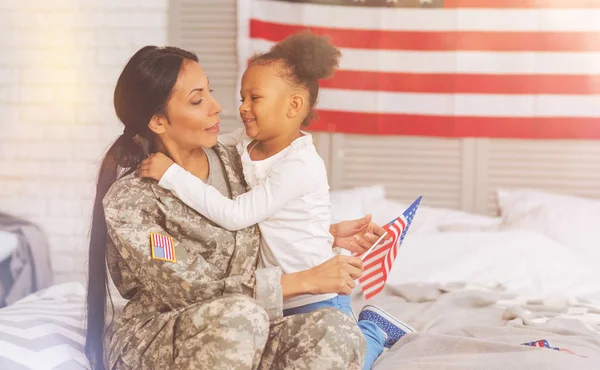 Tatlı anne ve kızı yatağa birbirlerine sarılma