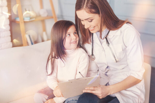 Positive delighted girl looking at her favorite doctor