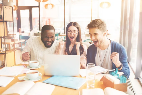 Estudiantes internacionales muy alegres sentados en el café —  Fotos de Stock