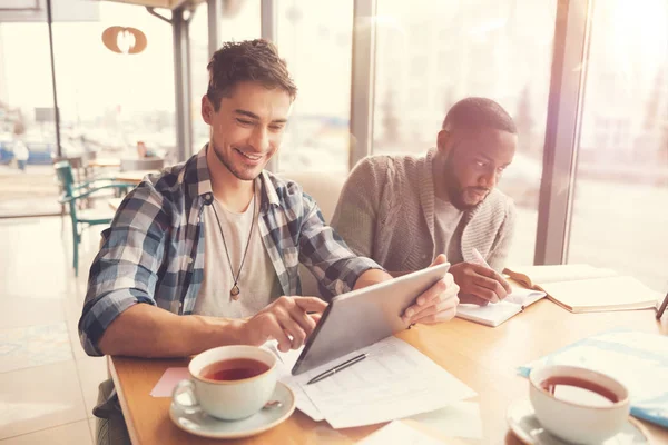 Masada oturan neşeli öğrenciler