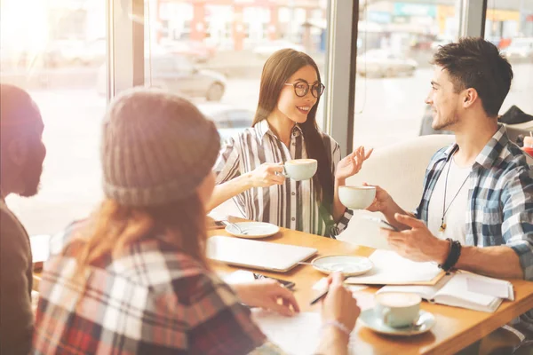 Neşeli öğrenciler kafeteryada konuşuyor
