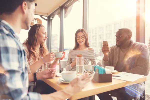 Kafede oturan neşeli uluslararası öğrenciler