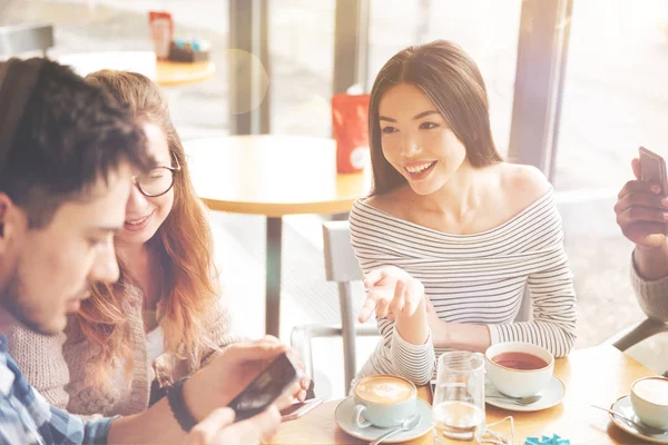 İnci kafede oturan olumlu uluslararası öğrenciler