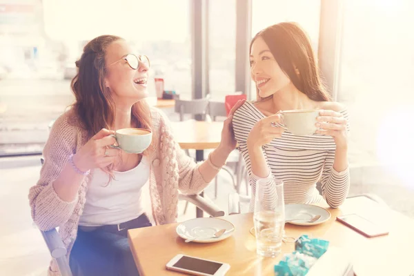 Mujeres amigas positivas descansando en la cafetería —  Fotos de Stock