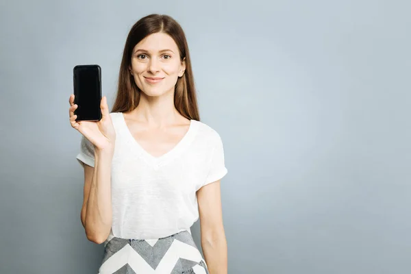 Okouzlující mladá žena prokazující její telefon — Stock fotografie