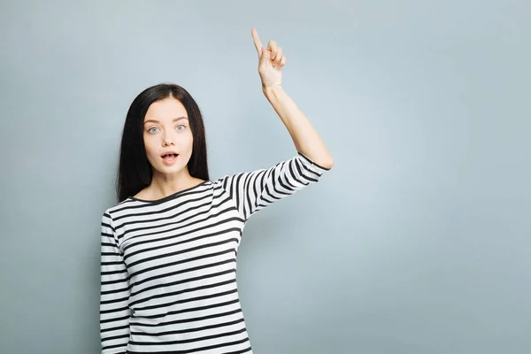 Mulher surpreendida levantando o dedo indicador — Fotografia de Stock