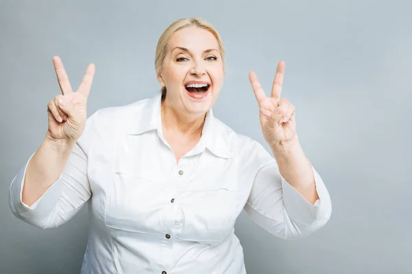 Mujer feliz mostrando signo de victoria —  Fotos de Stock