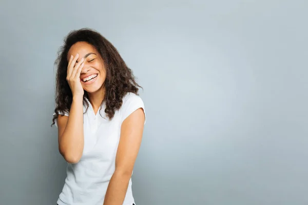 Feliz mulato hembra poniendo la mano en su cara — Foto de Stock