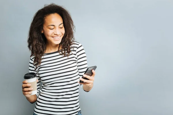 Pozitivní radost ženy při pohledu na její mobilní telefon — Stock fotografie