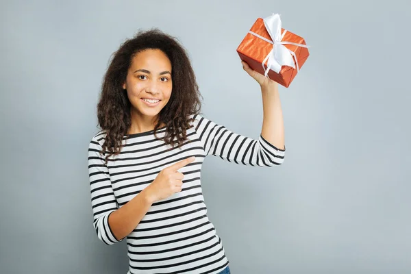 Blij brunette holding geschenkdoos — Stockfoto