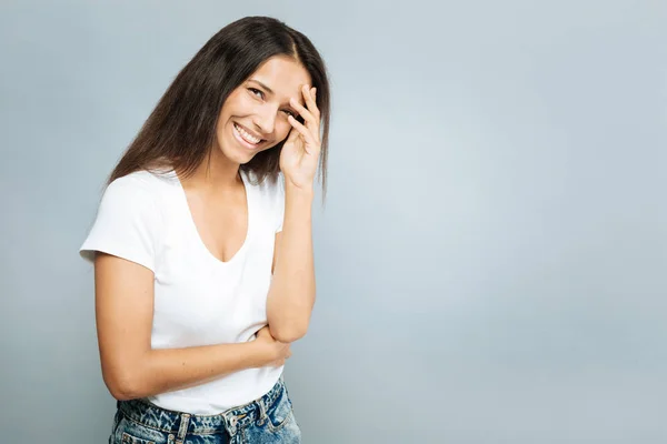 Entzückte Brünette zeigt freundliches Lächeln — Stockfoto