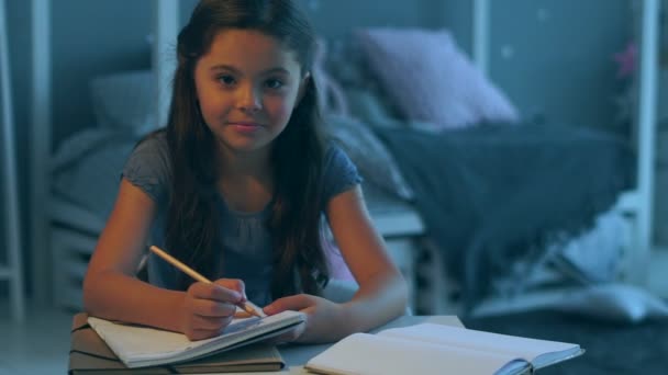 Красивая маленькая девочка сидит в своей спальне — стоковое видео