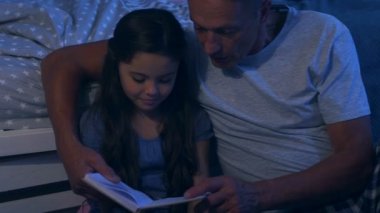 Tatlı küçük kız babasıyla bir kitap okuma