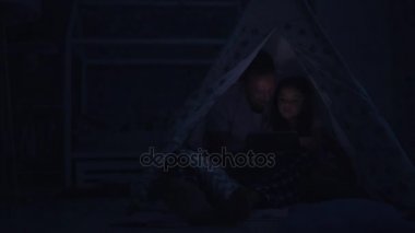 Küçük sevimli küçük kız ve babası evde kendi tablet kullanma