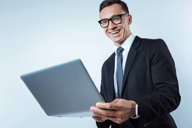 Parlak işadamı dizüstü bilgisayarda çalışan düşük açılı çekim