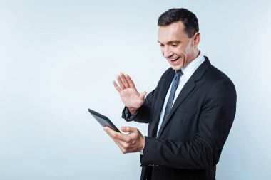 Görüntülü arama dijital tablet üzerinde sahip pozitif fikirli beyefendi