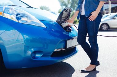 Bir elektro şarj arabaya takmayı güzel hoş kadın