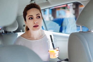 Bir bardak suyu tutan olumlu genç iş kadını