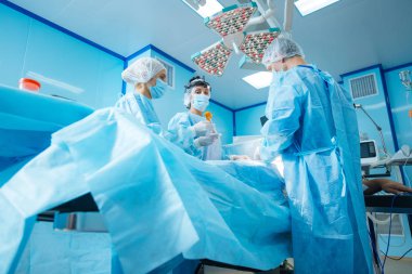 Cerrahi masa etrafında duran ciddi doktor