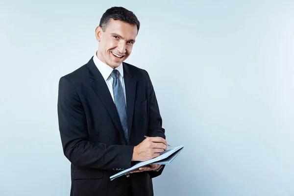 Joyful homem maduro observando algo no caderno — Fotografia de Stock