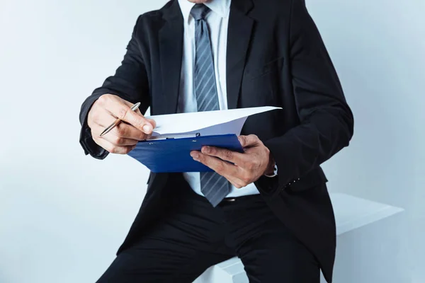 Nahaufnahme eines Geschäftsmannes, der durch Notizen schaut — Stockfoto