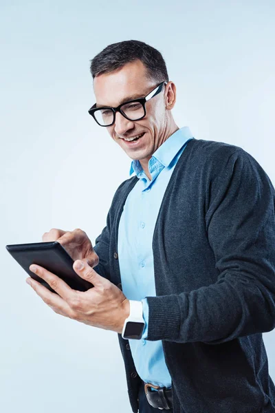 Glada mannen leende medan du arbetar på tablet PC — Stockfoto