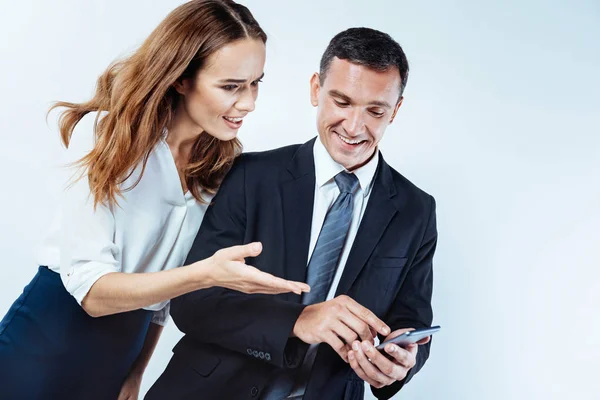 Donna curiosa che punta verso lo schermo dello smartphone del collega — Foto Stock