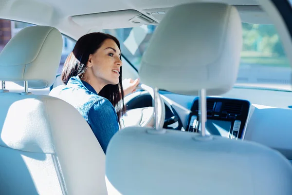 Jovem atraente sentada no carro — Fotografia de Stock