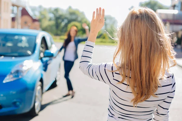 Nette junge Frau winkt mit ihrer Hand — Stockfoto