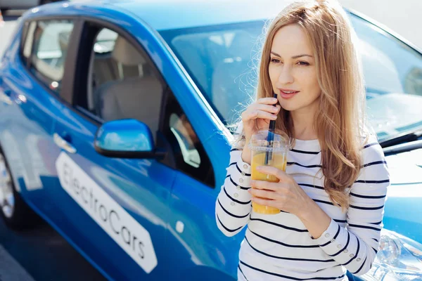 Joyful nice woman drinking orange juice — Stock Photo, Image