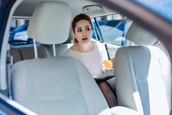 Attraktiva trevlig kvinna som sitter i baksätet på bilen — Stockfoto