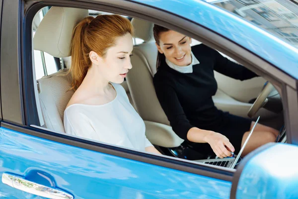 Dizüstü bilgisayar ekranında işaret çekici neşeli kadın