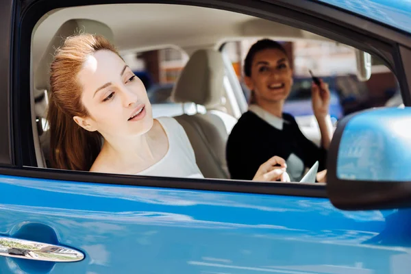 Attractive nice businesswoman sitting in the car with her colleague — Stock Photo, Image