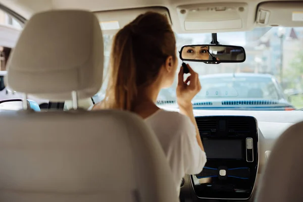 Mulher bonita atraente olhando para o espelho retrovisor — Fotografia de Stock