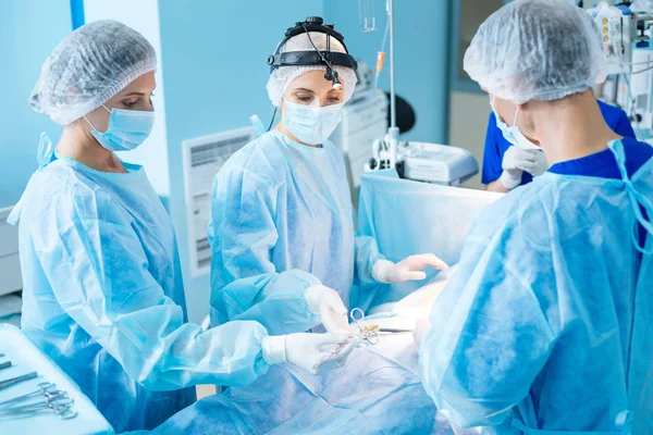 Trabalhador médico atento tomando instrumento estéril — Fotografia de Stock