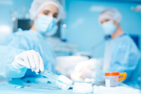 Primer plano de la mano femenina que toma instrumento médico — Foto de Stock