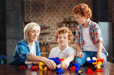 Çocuklar evde oynarken sevgi dolu büyükanne